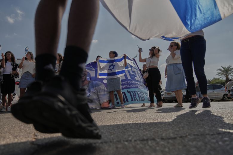 13일(현지시간) 가자지구 하마스 포로 석방 후 일부 석방된 인질들이 도착할 것으로 예상되는 이스라엘 페타 틱바의 베일린슨 병원 밖에서 사람들이 이스라엘 국기를 흔들며 기다리고 있다. [AP]
