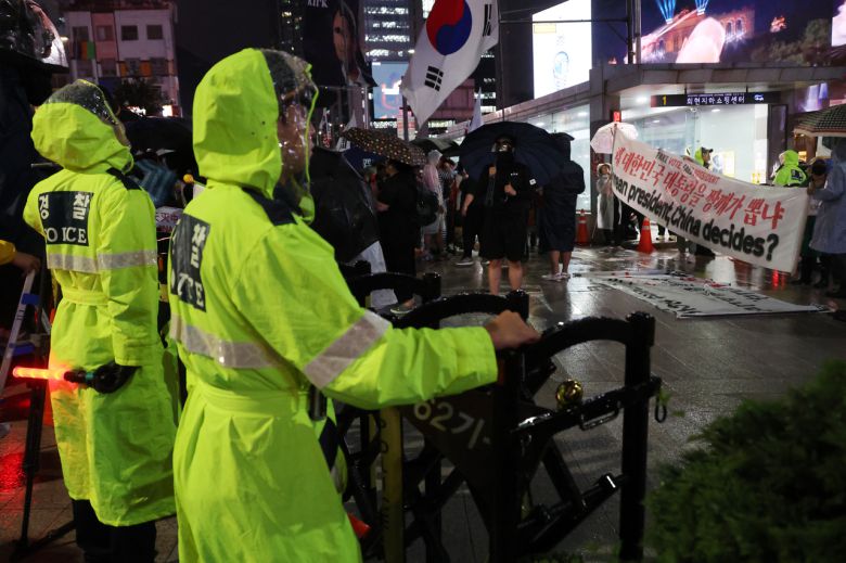 지난달 서울 명동 주한중국대사관 인근에서 경찰이 혐중 시위대의 명동 진입을 막는 바리케이드를 치고 있다. 오른쪽에 혐중 구호가 담긴 현수막이 보인다. [연합]