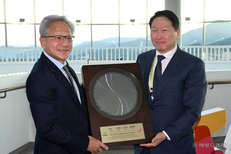 젠슨 황(왼쪽) 엔비디아 최고경영자(CEO)가 31일 경북 경주시 경주예술의전당에서 열린 APEC CEO 서밋 2025에 참석해 최태원 SK그룹 회장 겸 대한상공회의소 회장으로부터 SK하이닉스의 HBM4 반도체 웨이퍼를 선물로 받고 있다. 경주=임세준 기자