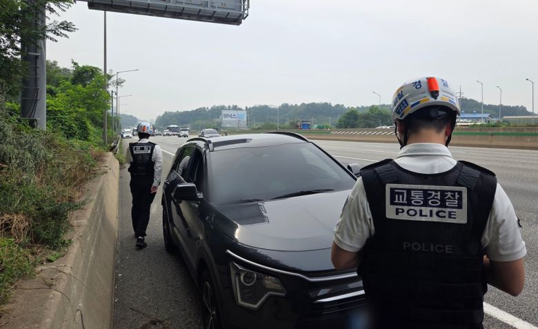 지난 10월 경기 안성시 경부고속도로 상행선에서 명절 연휴에 대비한 일제 교통단속에 나선 경기남부경찰청 고속도로순찰대 소속 경찰관이 차량 운전자에게 적발 사실을 알리고 있다. [연합]