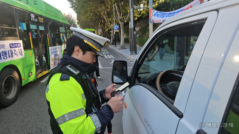 4일 오전 서울 서대문경찰서 소속 교통경찰이 연세대 교차로 앞에서 꼬리물기를 하다 걸린 트럭 운전자에게 범칙금 4만원을 부과하고 있다. 이용경 기자