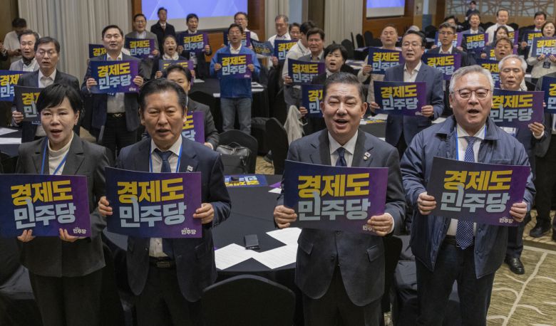 정청래(앞줄 왼쪽 두 번째) 더불어민주당 대표와 김병기(앞줄 오른쪽 두 번째) 원내대표를  비롯한 당직자와 지역위원장들이 11일 경기도 광주시 곤지암리조트에서 열린 2025년도 민주당 전국 지역위원장 워크숍에서 구호를 외치고 있다. [연합]