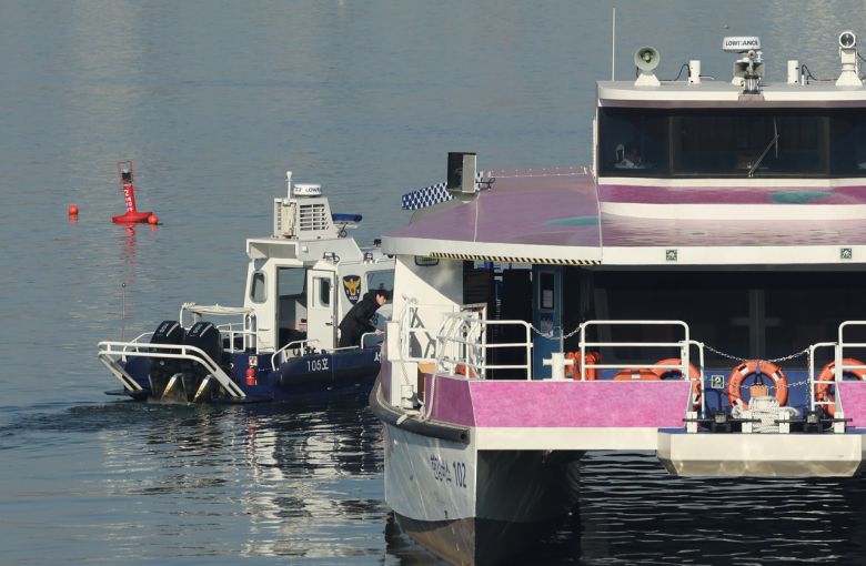 16일 서울 송파구 잠실선착장 부근 강바닥에 걸려 멈춘 한강버스와 주변 등대에서 경찰이 사고조사를 하고 있다. [연합]