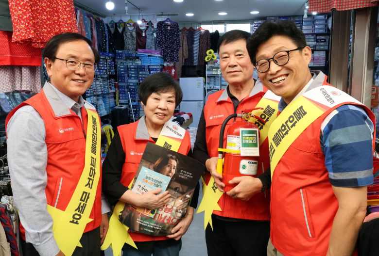 강영구(왼쪽 첫 번째) 한국화재보험협회 이사장이 지난해 9월 서울 동대문구 답십리 현대시장 상점가에서 열린 ‘모두가 안전한 전통시장 만들기’ 캠페인에서 정성관(오른쪽 첫 번째) 상인회 회장, 답십리 현대시장 상인들과 함께 기념촬영을 하는 모습.  [한국화재보험협회 제공]