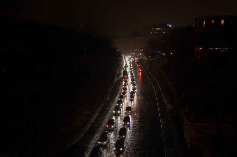 러시아가 27일(현지시간) 우크라이나 키이우에 대규모 공습을 단행한 뒤 키이우내 비상정전 조치가 내려지자 깜깜한 도로 위로 헤드라인을 켠 차량이 이동하고 있다. [AFP]