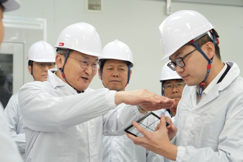 이석희(왼쪽에서 두 번째) SK온 사장이 5일 대전 대덕구 스탠다드에너지 생산동에서 김부기(오른쪽) 스탠다드에너지 대표로부터 바나듐이온배터리에 대한 설명을 듣고 있다. [SK온 제공]