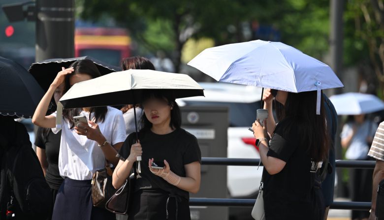 오전 서울 종로구 세종대로 사거리에서 시민들이 양산으로 뜨거운 햇살을 가리며 출근길을 서두르고 있다. 임세준 기자