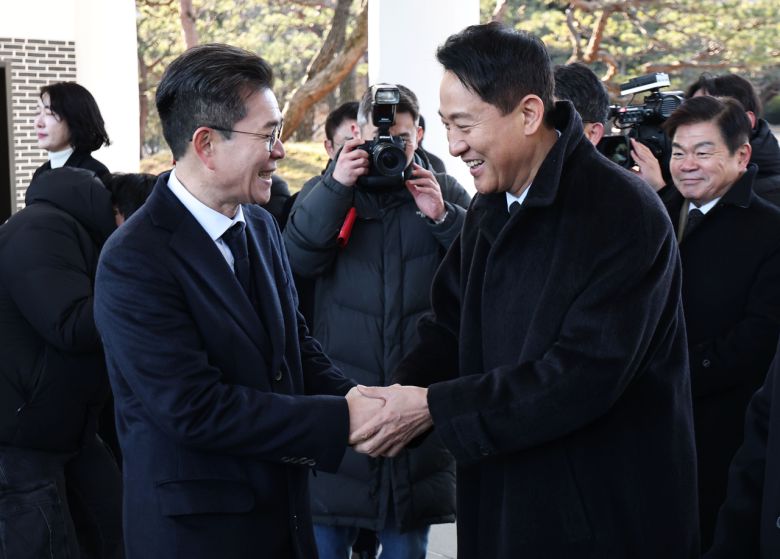 오세훈 서울시장(오른쪽)과 정원오 성동구청장이 새해 첫날인 1일 서울 동작구 국립서울현충원에서 현충탑에 참배를 마친 뒤 인사하고 있다. [연합]