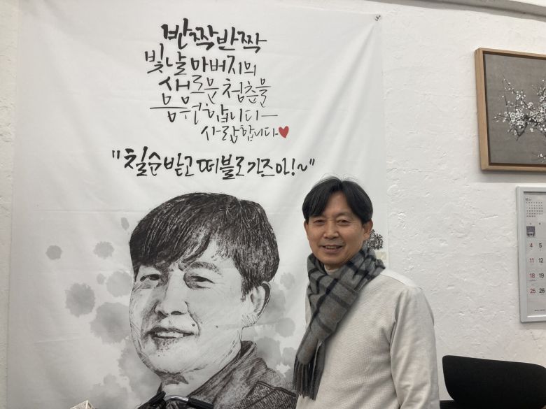 ‘인쇄 분야 서울 명장’ 김인호 동양상사지기인쇄 대표가 아들이 칠순 기념으로 선물한 응원 현수막 앞에서 웃고 있다. 손인규 기자