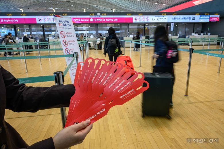 아시아나항공이 인천공항 제2여객터미널(T2) 운항을 개시한 14일 오전 인천국제공항 제2터미널 아시아나발권장에서 직원이 베터리 테그를 나눠주고 있다. 영종도=임세준 기자