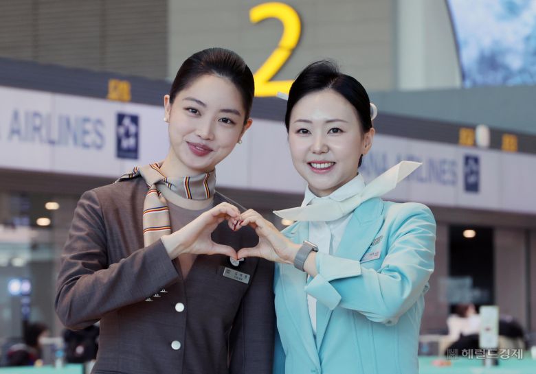 아시아나항공이 인천공항 제2여객터미널(T2)에서 운항을 시작한 14일 대한항공과 아시아나 승무원들이 손 하트를 하며 기념촬영을 하고 있다. 사진=박범준 기자