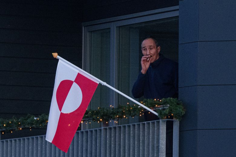 14일(현지시간) 그린란드의 수도 누크의 한 주민이 국기가 게양된 발코니에서 담배를 피우고 있다.[AP]