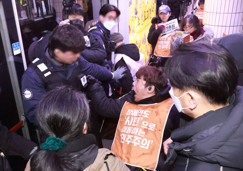 전국장애인차별철페연대(전장연) 회원들이 지난 2일 서울 지하철 1호선 시청역에서 제68차 ‘지하철 탑시다’ 시위를 벌이고 있다. [연합]