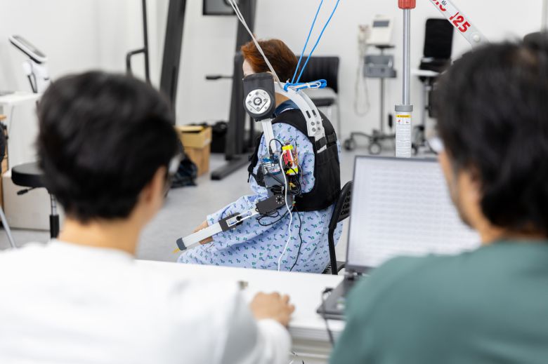 연구진이 환자가 직접 웨어러블 로봇을 착용하고 움직이는 상태에서 측정되는 데이터를 분석하고 있다.[ETRI 제공]