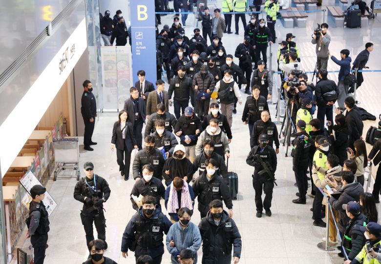 캄보디아에서 스캠(사기), 인질강도 등 범행을 저지른 한국인 범죄 조직원들이 23일 인천국제공항을 통해 국내로 송환돼 수사기관으로 압송되고 있다. [연합]