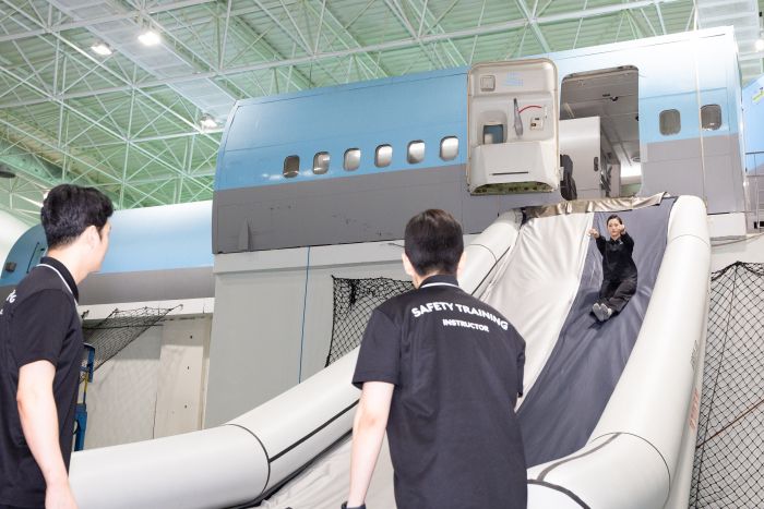 승무원들이 양손은 앞으로 쭉 뻗은 채 슬라이드로 뛰어내리고 있다. 사진=대한항공 제공