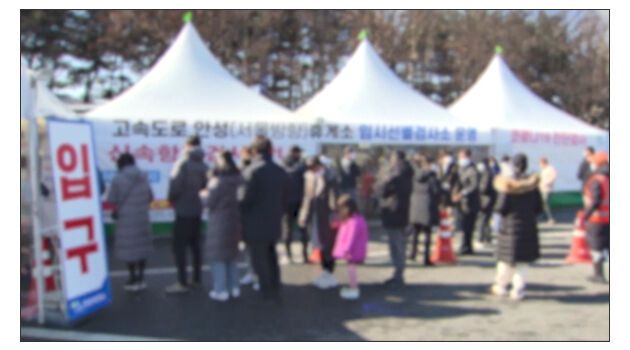 코로나 감염 여부 검사를 하기 위해 사람들이 임시 선별진료소 앞에 줄을 서 있다.