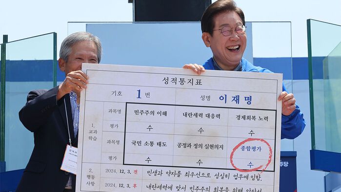 더불어민주당 이재명 대선 후보가 선거를 이틀 앞두고 '험지 공략'에 나선 1일 고향인 경북 안동시의 웅부공원에서 열린 유세에서 이 후보의 초등학교 은사인 박병기 선생님으로부터 대선 후보 모의 성적 통지표를 받고 있다.