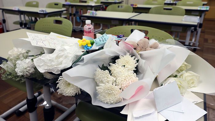지난달 25일 오후 최근 아파트 화재로 숨진 자매가 다닌 부산진구의 한 초등학교 교실 책상에 학생들이 보낸 선물과 편지가 올려져 있다.