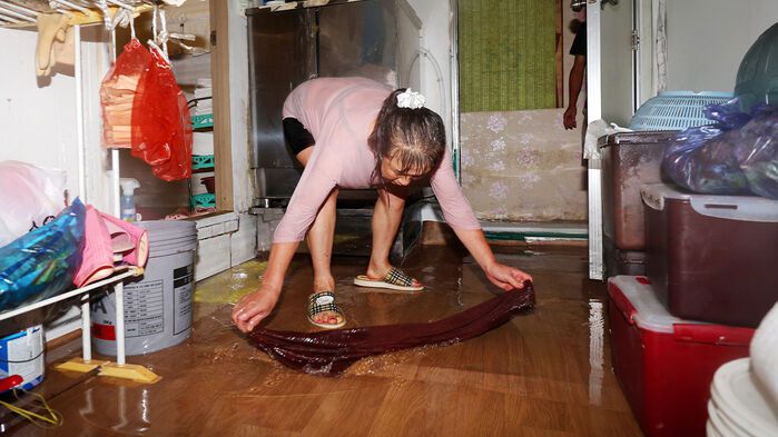 호우경보가 발효된 17일 오전 광주 남구 백운광장 인근 미용실이 물에 잠겨 업주가 배수 작업을 하고 있다.