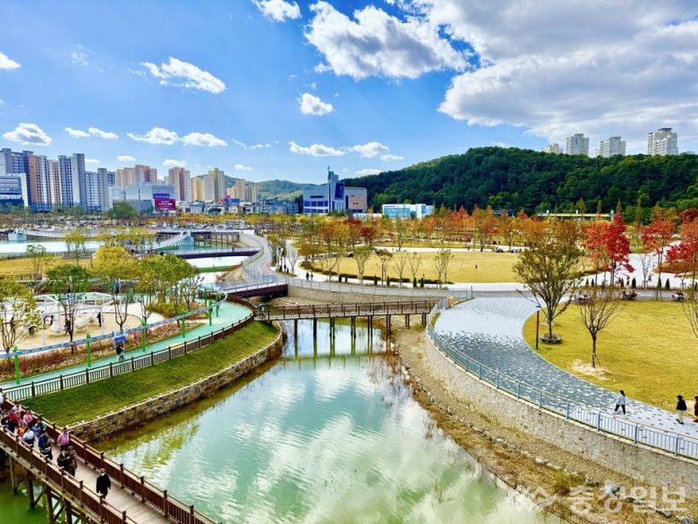 맑은 가을빛 아래 펼쳐진 갑천생태호수공원의 전경. 굽이진 수변 산책로와 연결 데크가 호수를 따라 이어지고, 곳곳에 자리한 녹지와 단풍이 계절감을 더한다