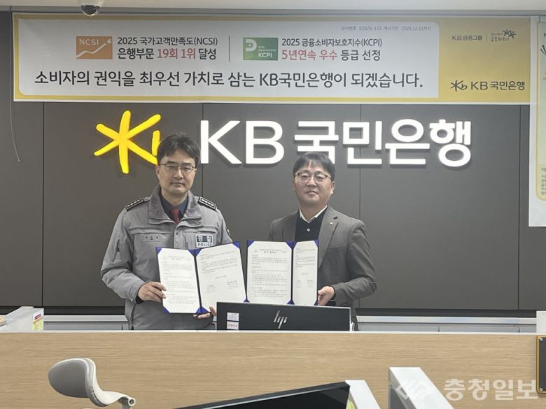 금융 거래 단계에서 보이스피싱을 차단하기 위한 협력 체계를 구축한 논산경찰서와 KB국민은행 논산지점. 업무협약 체결 후 협약서를 들어 보이고 있다