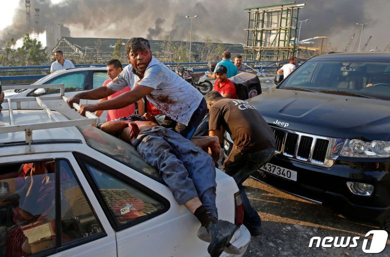 4일(현지시간) 레바논 베이루트항 선착장에 있는 창고에서 대규모 폭발사고로 부상을 당한 시민이 차량에 기대어 누워 있다. © AFP=뉴스1 © News1 우동명 기자
