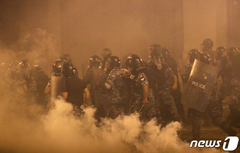 9일(현지시간) 최루탄 연기가 자욱한 가운데 레바논 경찰들이 시위를 진압하고 있다. © 로이터=뉴스1