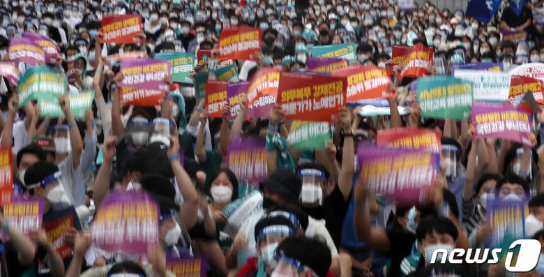 집단휴진 총파업에 나선 대한의사협회 회원들이 14일 오후 서울 영등포구 여의대로에서 열린 '4대 악(惡) 의료 정책 저지를 위한 전국의사총파업 궐기대회'에서 의과대학 정원 확대, 공공의대 설립, 한방 첩약 급여화, 비대면 진료 육성 등에 반대하며 손 피켓을 들고 있다. 2020.8.14/뉴스1 © News1 이동해 기자