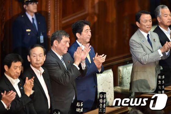 2015년 7월 일본 중의원 본회의에서 안보 관련 법안이 통과되자 아베 신조(安倍晋三) 총리(오른쪽 세번째)와 이시바 시게루(石破茂) 당시 지방창생담당상(오른쪽 네번째)이 박수를 치고 있다. © AFP=News1 최종일