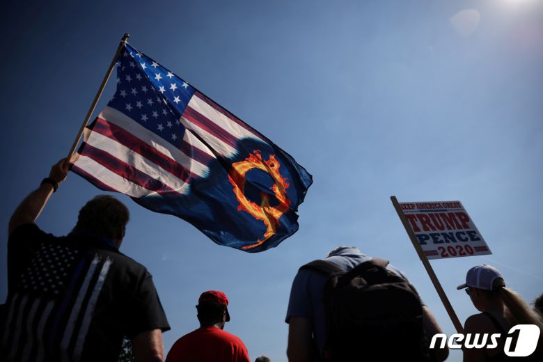 지난 9월7일 도널드 트럼프 미국 대통령 지지자들이 오리건주 포틀랜드에서 극우 음모론 단체 '큐어넌'이 적힌 성조기를 든 채 집회를 벌이고 있다. © 로이터=뉴스1