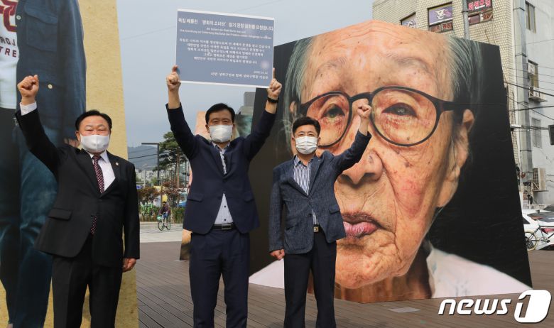 이승로 성북구청장 등이 12일 서울 성북구 한성대입구역 인근에서 열리고 있는 여성인권에 대해 생각하는 공공미술 작품전 'ALIGHT'를 배경으로 '독일 베를린 평화의 소녀상 철거 명령 철회를 요청' 하는 퍼포먼스를 하고 있다. 일본군 위안부 피해자를 기리는 소녀상은 국제적으로 전쟁시 여성피해 문제를 알리기 위해 독일 미테구(區)의 허가를 얻어 지난달 말 공공장소인 거리에 설치됐다. 그러나 설치 직후 일본 정부가 공식적으로 문제를 제기하고 독일 정부에 철거요청을 하자, 미테구는 지난 7일 전격적으로 철거 명령을 내렸다. 2020.10.12/뉴스1 © News1 송원영 기자