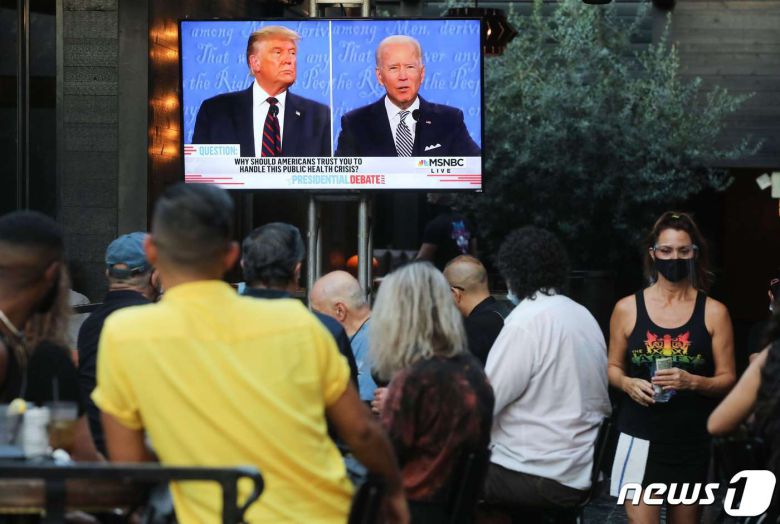 29일 (현지시간) 오하이오주 클리블랜드의 케이스 리저브 웨스턴 대학에서 열린 도널드 트럼프 미국 대통령과 조 바이든 민주당 대선 후보의 첫 대선 TV토론을 캘리포니아주 웨스트 할리우드의 시민들이 시청을 하고 있다. © AFP=뉴스1 © News1 우동명 기자