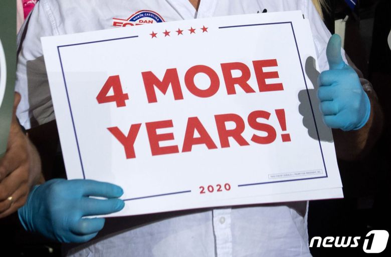 21일(현지시각) 도널드 트럼프 미국 대통령의 노스캐롤라이나주 개스토니아 공항 대선 집회에서 지지자가 ‘4년 더’ 가 쓰인 팻말을 들고 있다. © AFP=뉴스1 © News1 우동명 기자
