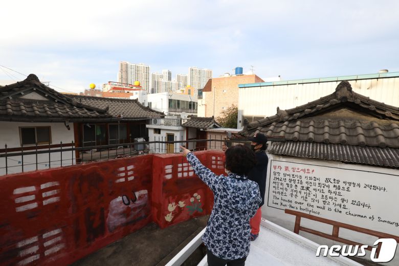 이건희 삼성그룹 회장 별세 소식이 전해진 25일 오후 대구 중구 인교동 호암 이병철 고택 담장 밖에서 시민들이 내부를 살펴보고 있다. 이곳은 이건희 회장의 생가로 알려졌으며 이 회장은 이곳에서 유년시절을 보냈다고 전해진다. 외벽에 ‘부자 기(氣) 받으세요!’라는 문구와 안내문이 눈길을 끈다. 2020.10.25/뉴스1 © News1 공정식 기자