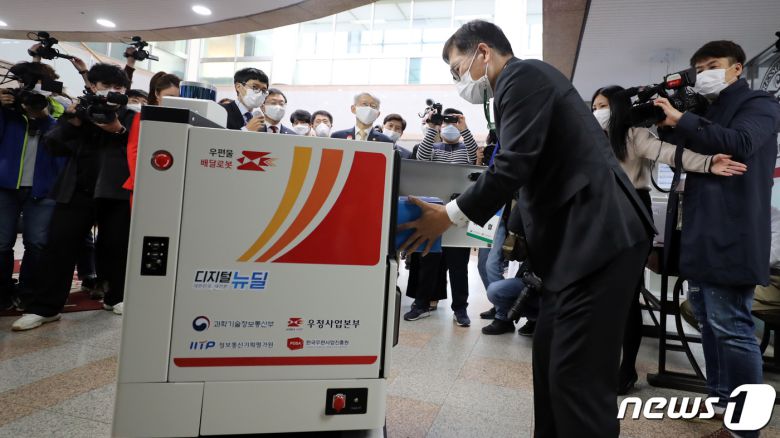 28일 세종시 조치원읍 고려대 세종캠퍼스에서 열린 우정사업 자율주행 시연 행사에서 수령인이 배달로봇에서 소포를 꺼내고 있다. 과학기술정보통신부와 우정사업본부는 이날 행사에서 무인우체국과 집배원 추종로봇, 배달로봇을 선보였다. 2020.10.28/뉴스1 © News1 장수영 기자