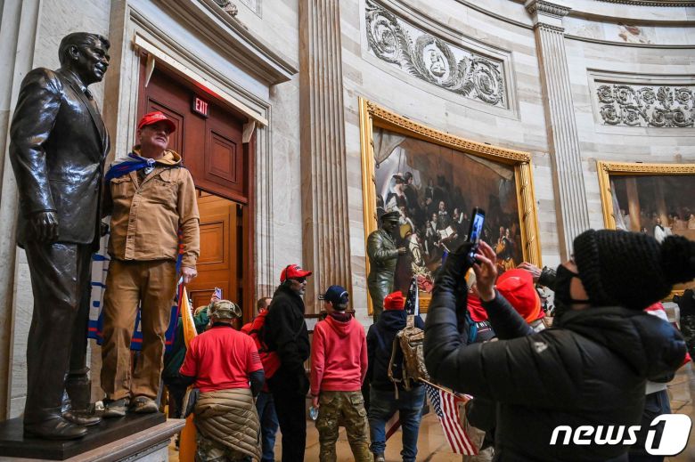 6일(현지시간) 워싱턴 의사당에 난입한 도널드 트럼프 미국 대통령을 지지하는 시위대가 기념촬영을 하고 있다. © AFP=뉴스1 © News1 우동명 기자