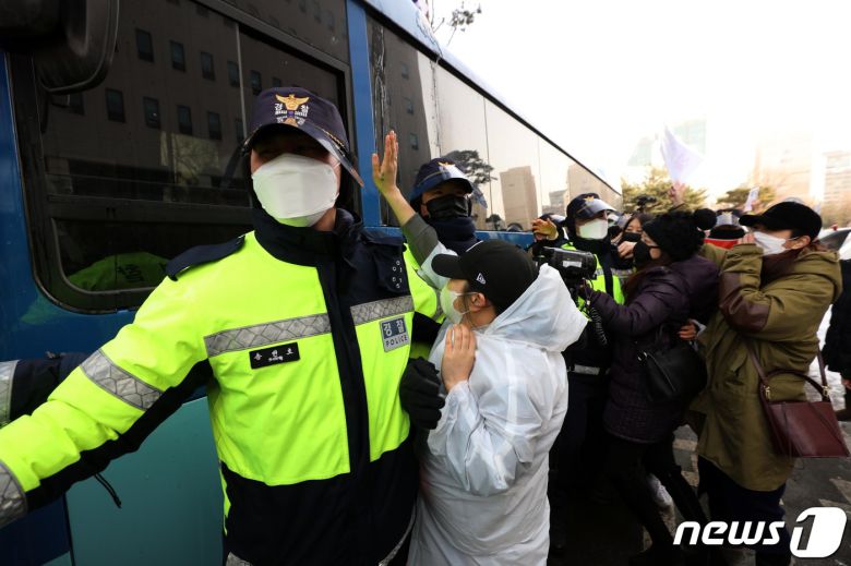 정인양을 입양한 후 수개월간 학대해 사망에 이르게 한 혐의를 받는 양부모에 대한 첫 재판이 열린 13일 오전 서울 양천구 서울남부지방법원에서 양모가 탄 것으로 추정되는 호송차가 나오자 시민들이 분노를 표출하고 있다. 2021.1.13/뉴스1 © News1 이승배 기자