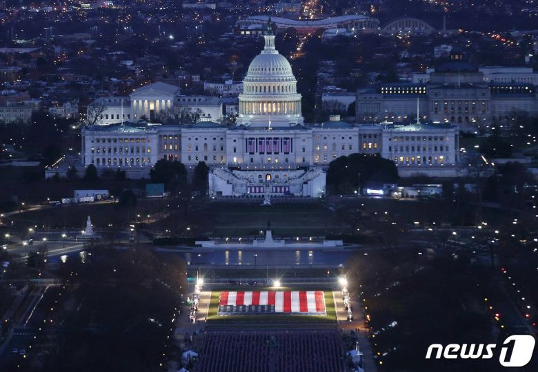18일(현지시간) 조 바이든 미국 대통령 당선인의 취임식을 앞두고 워싱턴 내셔널 몰 앞에 꽂힌 19만 개의 깃발 벌판에 조명이 비치고 있다. © AFP=뉴스1 © News1 우동명 기자