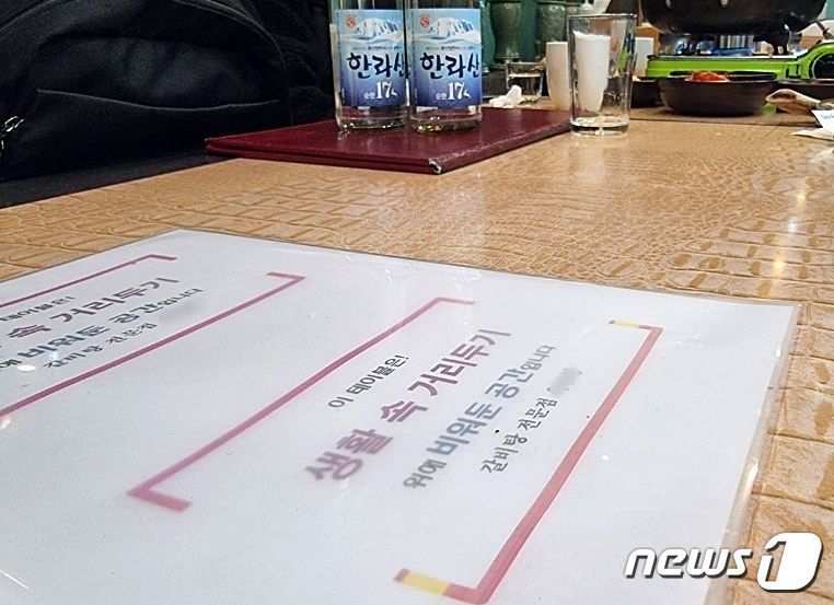 비수도권 식당 영업시간이 연장된 첫날인 8일 저녁 제주시 아라동의 한 식당 테이블에 거리두기 방역지침이 적혀 있다.2021.2.8/뉴스1© News1 오현지 기자