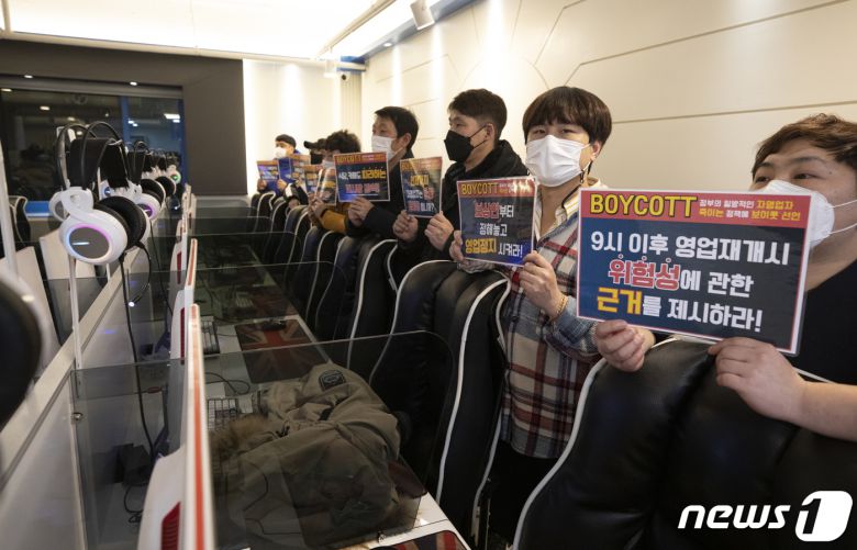 8일 새벽 서울 강서구의 한 PC방에서 신종 코로나바이러스 감염증(코로나19) 대응 전국자영업자비상대책위원회(비대위) 주최로 열린 코로나19 관련 일괄적인 영업시간제한 폐지 등을 촉구하는 '방역기준 불복 개점시위 기자회견'에서 참석자들이 피켓을 들고 있다. 2021.2.8/뉴스1 © News1 이승배 기자