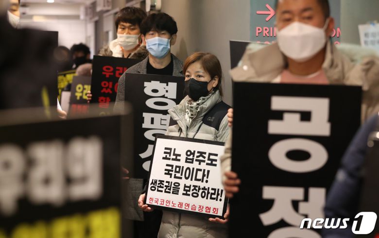 코인노래방 점주들이 9일 0시 서울 서대문구의 한 코인노래연습장에서 21시 영업시간제한 폐지를 촉구하며 개점시위를 벌이고 있다. 2021.2.9/뉴스1 © News1 박지혜 기자