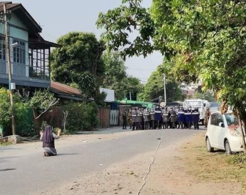 안 로사 누 타웅 수녀가 무장한 경찰들 앞에 무릎을 꿇고 시위대에 사격을 하지 말아달라고 호소하고 있다. (찰스 마웅 보 추기경 트위터 갈무리/뉴스1)