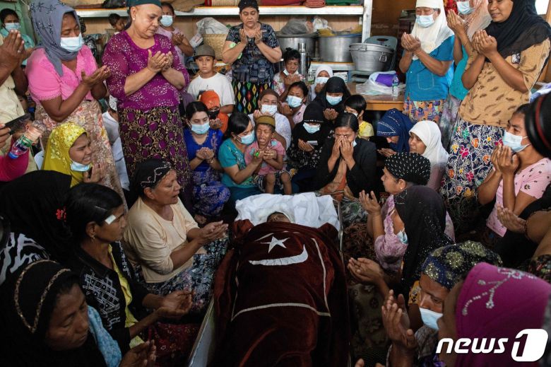 1일 가족과 친척들이 반쿠데타 시위에 참여했다가 사망한 한 무슬림 여성의 시신 옆에서 기도하고 있다. © AFP=뉴스1