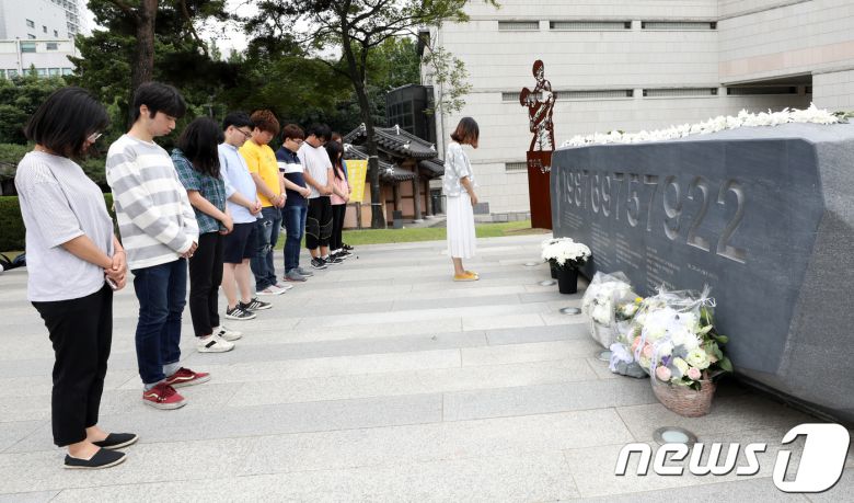 10일 오후 서울 서대문구 연세대학교 한열동산에서 학생들이 고(故) 이한열 열사 추모비에 헌화 후 묵상을 하고 있다. 이한열 열사는 연세대 재학 당시인 1987년 전경이 쏜 최루탄에 맞아 사망했다. 이 열사의 죽음은 6월 항쟁의 도화선이 됐다. 2018.6.10/뉴스1 © News1 박지수 기자