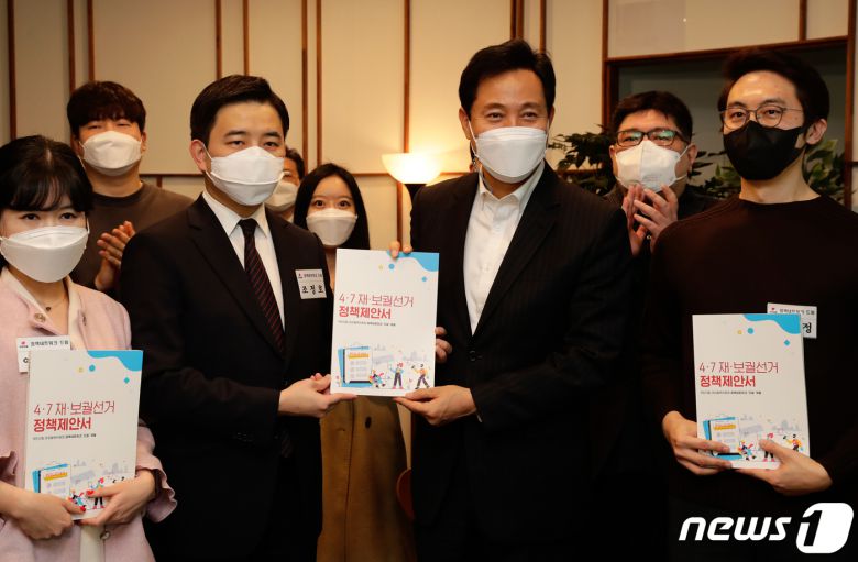 오세훈 국민의힘 서울시장 후보가 7일 서울 영등포구 여의도에 있는 한 카페에서 열린 당 대외협혁위원회 정책네트워크 드림이 엮은 '4.7 재·보궐선거 정책제안서집' 전달식에 참석해 제안서집을 받고 있다. 2021.3.7/뉴스1 © News1 성동훈 기자