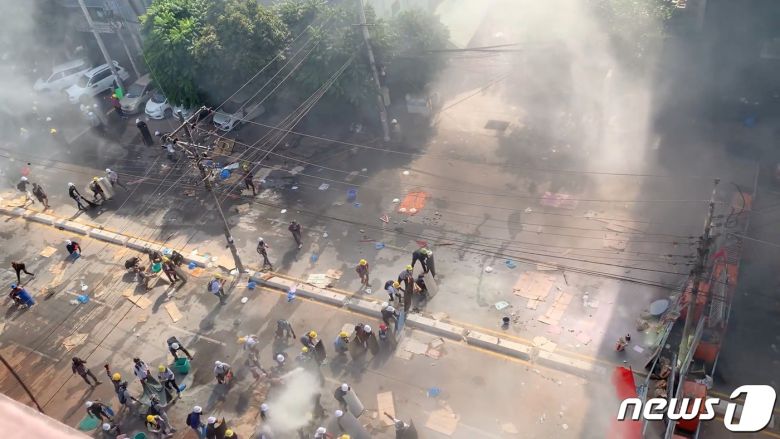 미얀마 최대 도시 양곤에서 2021년 3월 4일 군부 퇴진을 요구하는 시위대와 이를 진압하는 군·경이 뒤얽힌 가운데 최루탄 연기가 자욱한 모습. © 로이터=뉴스1 © News1 최서윤 기자