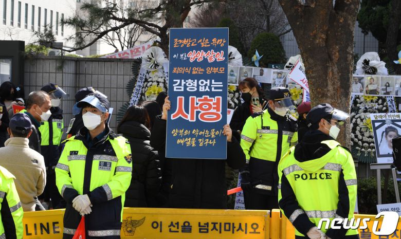 양부모 학대로 숨진 '정인이 사건' 4차 공판이 열린 17일 오후 서울 양천구 남부지방법원 앞에서 시민들이 손팻말을 들고 양부모에 대한 강력한 처벌을 촉구하고 있다. 2021.3.17/뉴스1 © News1 황기선 기자