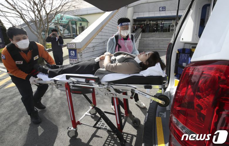 18일 오전 울산 중구 동천체육관에 마련된 코로나19 예방접종센터에서 지역 예방접종센터 모의훈련이 실시된 가운데 의료진과 구급대원이 이상반응 발생 접종대상자를 구급차로 이송하고 있다. 2021.3.18 /뉴스1 © News1 윤일지 기자