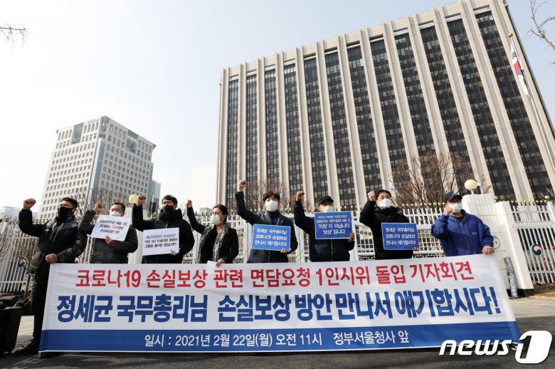 11개 중소상인·실내 체육시설 관계자들이 지난 2월22일 서울 종로구 정부서울청사 앞에서 열린 릴레이 1인 시위 피켓팅 돌입 기자회견에서 코로나19 손실 보상을 촉구하는 구호를 외치고 있다.  2021.2.22/뉴스1 © News1 오대일 기자
